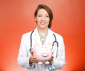 Closeup portrait female health care professional, doctor, nurse with stethoscope holding piggy bank, dollar bill, isolated red background. Medical insurance, medicare reimbursement, reform concept.jpeg
